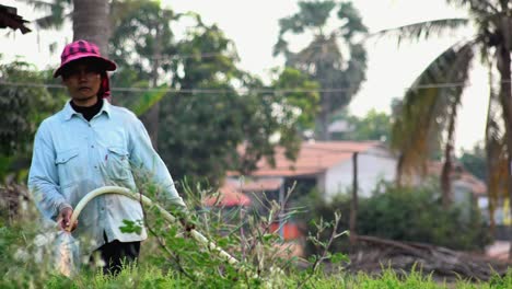 Kambodschanische-Frau-Bewässert-Die-Ernte-Auf-Einem-Feld-Auf-Einem-Bauernhof