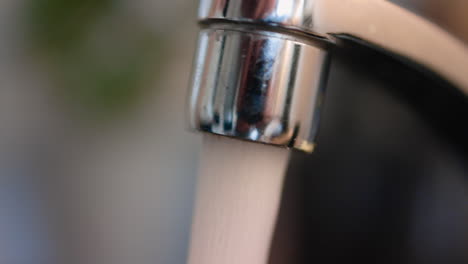 Tap-water-flowing-out-in-a-close-up-of-a-sink's-nozzle