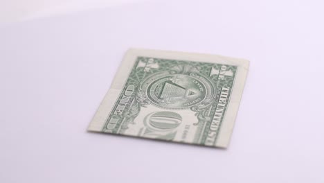 Un-Dólar-Gire-Sobre-Fondo-Blanco-En-El-Estudio-Fotográfico