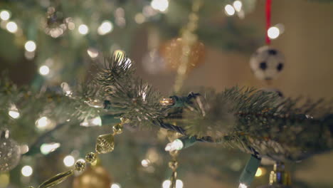 Luces-Centelleantes-Y-Adornos-En-Un-árbol-De-Navidad-Artificial-Plateado