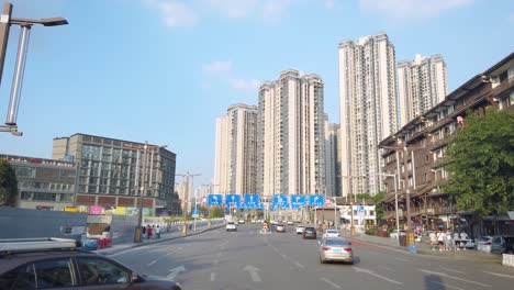 Private-cars-driving-on-a-multi-lane-highway-towards-highrise-residential-apartments-and-buildings-in-Chongqing-city-suburb