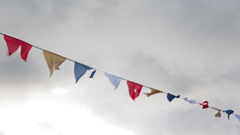 Colorful-flags-on-rope-hanging-outside-in-cloudy-day