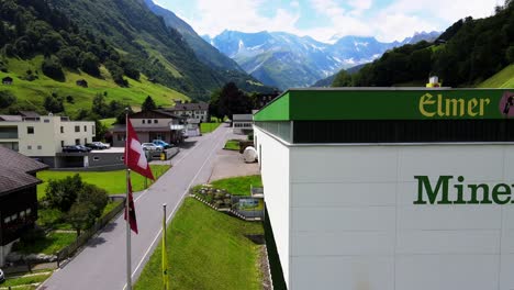 Aerial-shot-of-Logo-of-Elmer-mineral-water-plant-in-Elm,-Glarus,-Switzerland