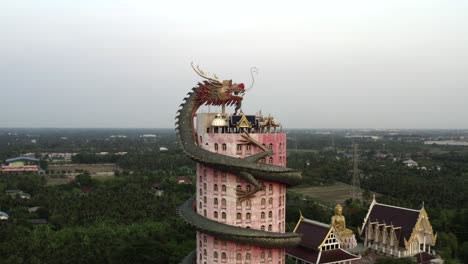 Drone-Fly-By-Giant-Dragon-Sculpture-on-Buddhist-Temple,-Wat-Samphran