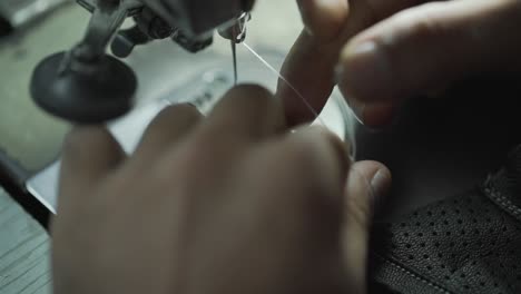 Closeup-Of-Worker-Threading-Cotton-On-A-Sewing-Machine,-Clothing-Manufacturing-Factory