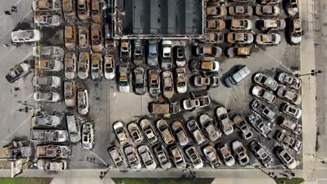 DRONE-SHOT-OVERHEAD-OF-BURNT-UP-CARS-IN-A-PARKING-LOT