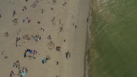 Top-down-aerial-of-families-gathering-at-a-beach-after-city-restrictions-ease-from-the-COVID-19-pandemic