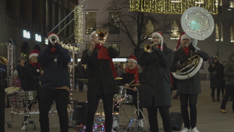 Street-musicians-dressed-as-Santa-Claus-play-trumpets-and-drums