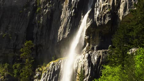 Rugged-mountainside-with-cascading-waterfall,-slow-motion
