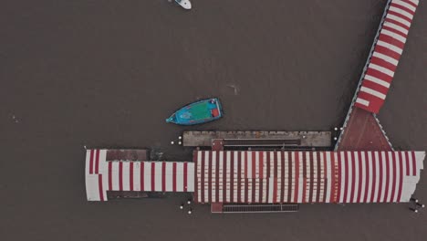 Top-down-drone-shot-of-passenger-and-speed-boat-docking-at-mandwa-jetty-India
