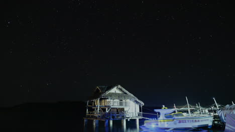 Star-trails-facing-the-ocean-with-a-nipa-hut-and-boats-docked