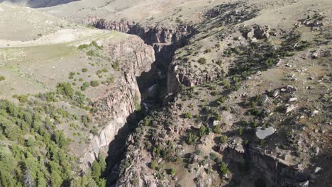 Kippbare-Luftaufnahme-Von-Shell-Creek-Und-Seinen-Hohen-Canyonwänden-Entlang-Der-Route-14-In-Wyoming-An-Einem-Sommertag