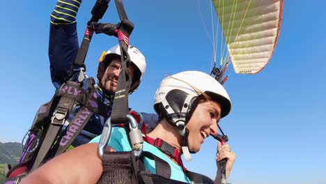 Close-up-beautiful-woman-tandem-paragliding-on-sunny-day