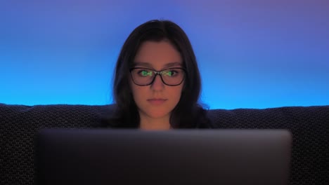 Young-Woman-With-Glasses-Working-Late-on-Laptop-Computer-in-Comfort-of-Her-Room