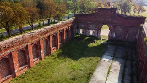 Aerial-view-of-former-russian-tsar-army-gymnastics-hall-in-Karosta,-Liepaja,-used-for-gymnastics-performances-and-competitions-for-horseback-riders,-wide-angle-birdseye-drone-shot-moving-forward