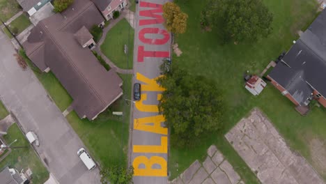 Bird-eye-view-of-a-large-"Black-Towns-Matter"-sign-painted-on-street-in-Houston-Historical-independence-Heights-district