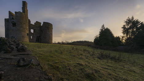 Time-lapse-of-a-medieval-castle-ruin-in-rural-countryside-of-Ireland-during-sunset-evening