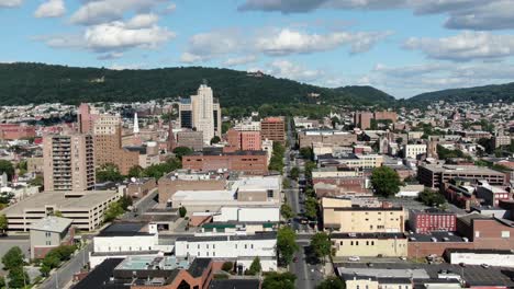 Cinematic-aerial-reveal-shot-of-Reading-Pennsylvania-downtown-business-district,-beautiful-summer-day-with-puffy-clouds,-American-town,-USA-urban-setting