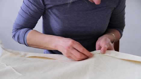 woman-hand-sewing-with-needle-and-thread-in-a-factory-on-a-table-stock-video