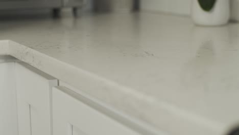 Glattes-Regal-Mit-Fokus-Auf-Einer-Arbeitsplatte-Aus-Weißem-Granit-In-Einer-Neu-Renovierten-Küche