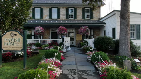 Amish-Farm-and-House-decorated-with-hanging-flower-planters,-Lancaster-County-tourist-destination-for-Anabaptist,-Mennonite-heritage