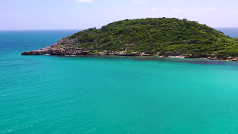 Isla-Con-Follaje-En-Un-Mar-Azul,-Bahía-De-Media-Luna,-Antigua-Y-Barbuda,-Caribe