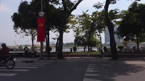 Vista-Estabilizada-De-La-Calle-Itinerante-De-Motociclistas-Y-El-Paseo-Marítimo-Del-Río-Saigón-En-El-Distrito-Uno-De-La-Ciudad-De-Ho-Chi-Minh,-Vietnam