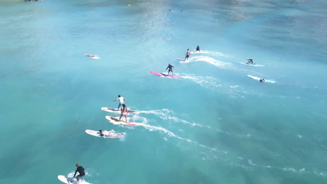 Aerial-of-group-of-surfers-on-small-wave-by-Waikiki-Beach-in-Honolulu
