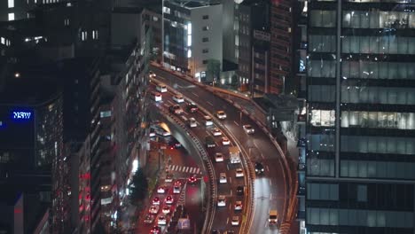 Starker-Verkehr-Auf-Der-Autobahn-Mit-Hochhaus-In-Der-Nacht-In-Shibuya,-Tokio,-Japan