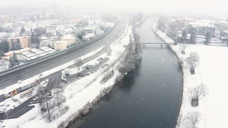 Stationäre-Aufnahme-Eines-Flusses-Und-Einer-Autobahn-Bei-Stürmischem-Schneewetter