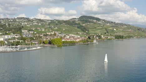 Flug-In-Richtung-Stadt-Lutry,-Vorbei-An-Einem-Segelboot,-Sommersaison-Lutry,-Lavaux-–-Schweiz