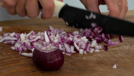 Dicing-a-red-onion-in-preparation-to-stir-fry-on-a-cutting-board