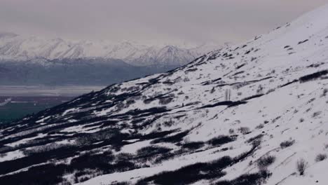 Flying-across-frozen-mountain-landscape-in-Anchorage,-Alaska