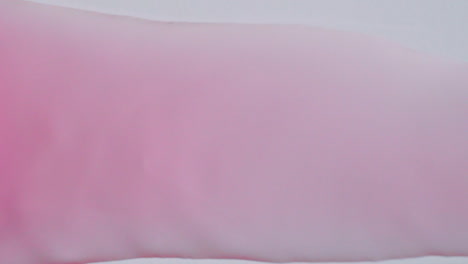Pink-bubble-water-flowing-from-right-to-left-on-a-white-paper-background