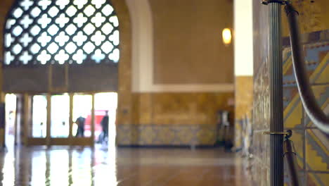 Blurry-background-shot-of-travelers-walking-through-the-entrance-hall-of-Union-Station-in-Los-Angeles,-California