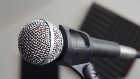 Close-up-on-a-music-bedroom-studio-vocal-microphone-during-a-podcast-recording-session-with-a-pop-filter