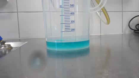 Se-Vierten-360-Ml-De-Un-Limpiador-Químico-Azul-En-Una-Taza-Medidora
