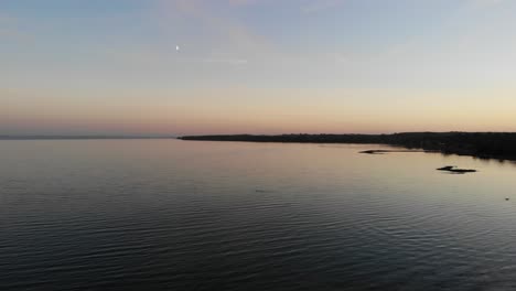 Luftaufnahme,-Die-über-Das-Meer-In-Nykøbing-Bugt-Fliegt,-Mit-Schwimmenden-Und-Fliegenden-Seevögeln-Bei-Einem-Wunderschönen-Sonnenuntergang