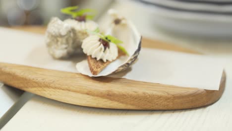 Oysters-on-a-wooden-tray-decorated-with-small-appetizing-snacks