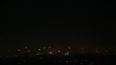 Many-fireworks-going-off-over-city-in-bottom-third-of-frame