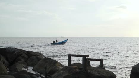 Einsamer-Bootsmann,-Der-über-Seinem-Boot-Steht,-Während-Es-über-Das-Wasser-Im-Bezirk-Koh-Phangan,-Surat-Thani,-Thailand,-Fährt