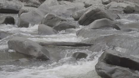 Stream-of-water-flowing-between-rocks-in-slow-motion