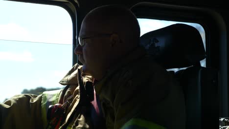 Firefighter-riding-inside-a-fire-truck-on-public-roads-viewed-from-inside-cab