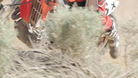 Cámara-Lenta:-Un-Motociclista-Conduce-Su-Motocicleta-Roja-Por-El-Desierto-Y-Gira-Alrededor-De-Una-Berma