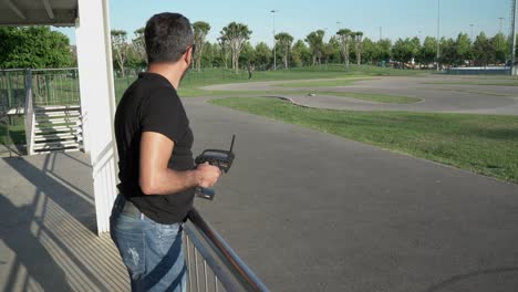 A-man-is-playing-with-his-remote-controlled-rc-radio-car-on-the-track
