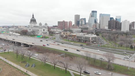 traffic-in-downtown-minneapolis,-skyline-during-a-cloudy-afternoon,-aerial-view