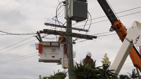 Electrical-contractors-working-on-a-crane-repairing-fallen-power-lines-from-a-recent-tropical-cyclone