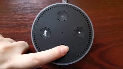 Close-up-video-of-a-girl-turning-down-the-volume-on-the-Alexa-Echo-Dot-Amazon-device