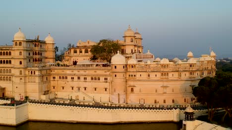 Filmischer-Schwenk-Aus-Der-Luft-Bei-Sonnenuntergang-Des-Stadtpalastes-Von-Udaipur,-Rajasthan,-Indien