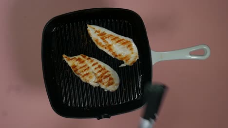 Top-view-of-turning-over-cooked-and-greased-chicken-breast-fillet
